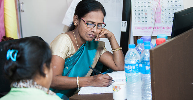 woman sitting at a desk filling out papers