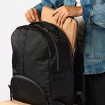 Woman wearing black carry-on travel backpack front view. #black
