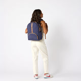 Woman carrying indigo travel backpack back view. #indigo_and_camel