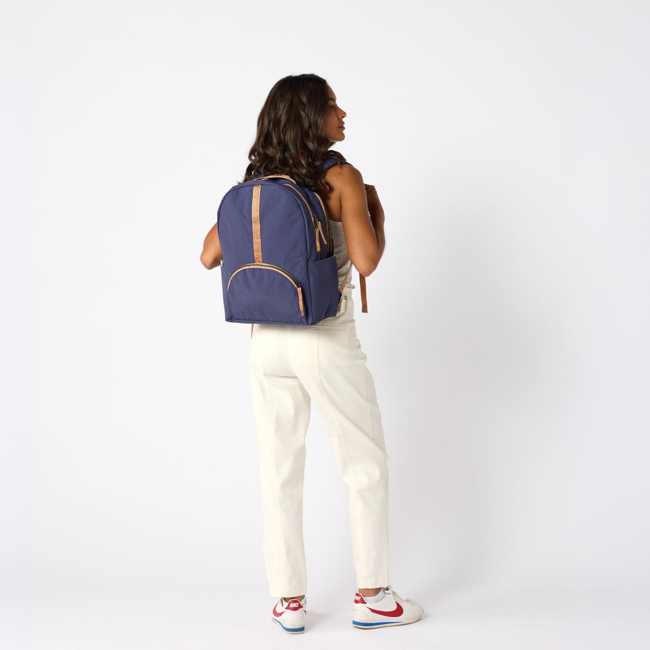 Woman carrying indigo travel backpack back view. #indigo_and_camel