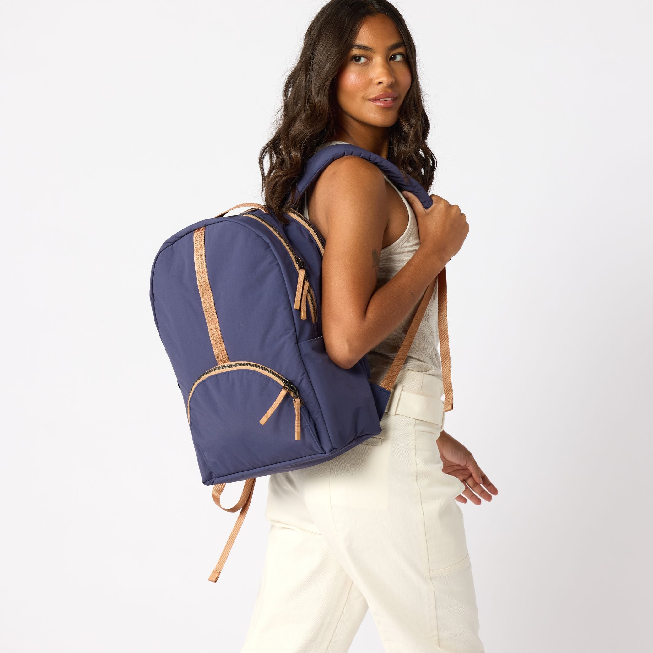 Woman wearing navy carry-on travel backpack front view. #indigo_and_camel