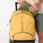 Laptop sliding into back sleeve of amber travel backpack. #amber_yellow
