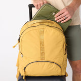 Laptop sliding into back sleeve of amber travel backpack. #amber_yellow