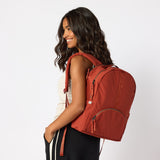 Woman wearing rust red travel backpack front view. #rust_red