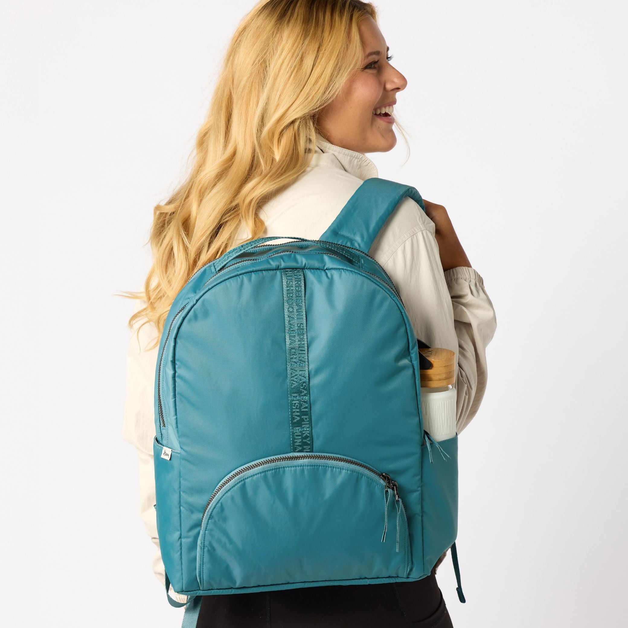 Teal travel backpack back view with shoulder straps. #solid_teal