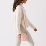 Pink crossbody bag with a strap on a white background #blush