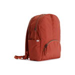 Rust Red Geeta nylon backpack, side profile showing the slim depth, side pocket and padded shoulder straps. #rust_red