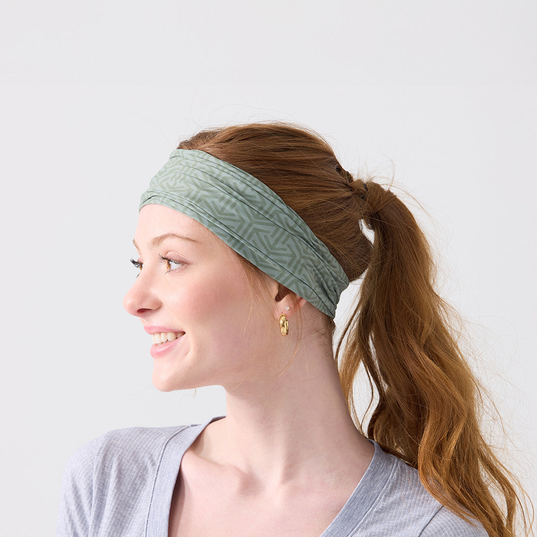Woman wearing a green headband against a white background