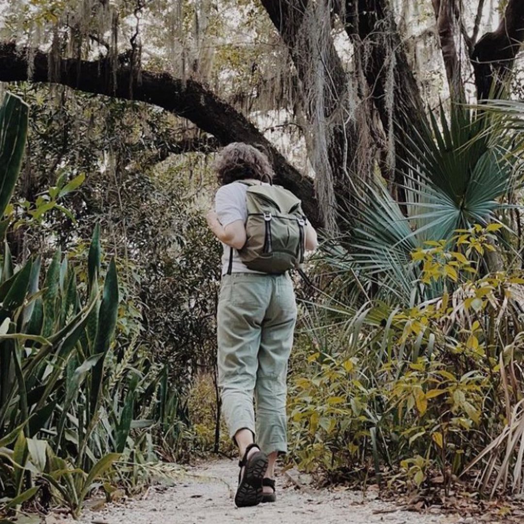 Person with a backpack walking through a lush forest - #olive sonu backpack